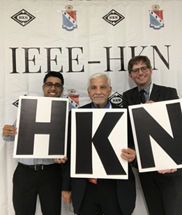 3 men holding HKN letters